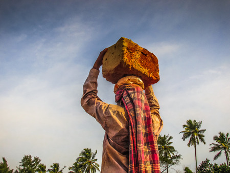 Unknowns women workers carrying stone on the head in Gokarna beach Karnataka India December 03-2017 on the morningのeditorial素材