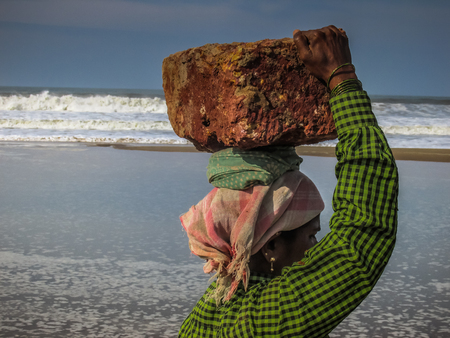 Unknowns women workers carrying stone on the head in Gokarna beach Karnataka India December 03-2017 on the morningのeditorial素材