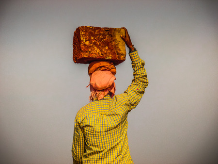 Unknowns women workers carrying stone on the head in Gokarna beach Karnataka India December 03-2017 on the morningのeditorial素材