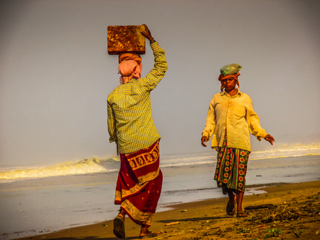 Unknowns women workers carrying stone on the head in Gokarna beach Karnataka India December 03-2017 on the morningのeditorial素材