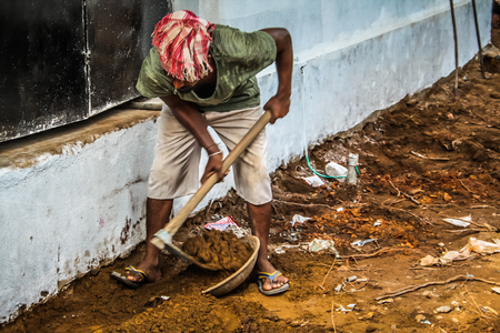 Unknown worker building a street sidewalk in Palolem Goa India October 28-2017 morningのeditorial素材