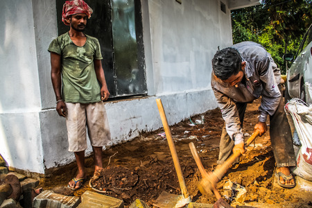 Unknown worker building a street sidewalk in Palolem Goa India October 28-2017 morningのeditorial素材