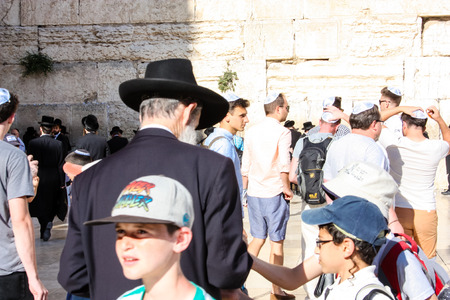 Jerusalem Israel May 14, 2018 unknown religious people offering a gift to children on the Western Wall Square in Jerusalem late afternoonのeditorial素材