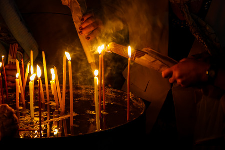 Lighting candles in the Church of the Holy Sepulchre in the Old City of Jerusalem