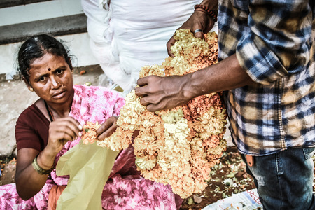 Gokarna Karnataka India November 01, 2017 Portrait of unknown people selling flowers in the street of Gokarna town in the eveningのeditorial素材