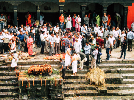 Kathmandu Nepal August 27, 2018 Hindu people attending a religious ceremony, the cremation of a dead body front the river at the Pashupatinath temple in the afternoonのeditorial素材