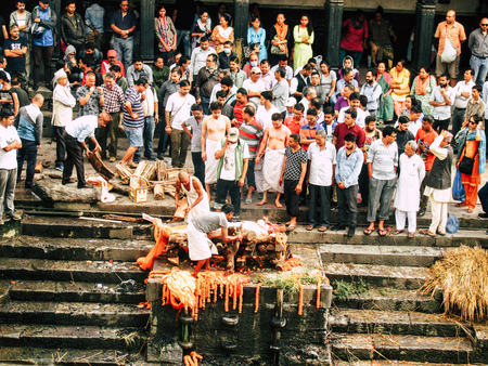 Kathmandu Nepal August 27, 2018 Hindu people attending a religious ceremony, the cremation of a dead body front the river at the Pashupatinath temple in the afternoon