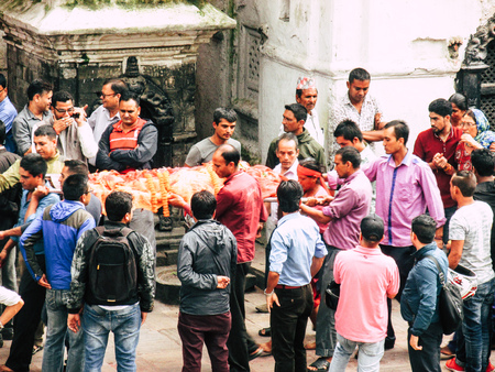Kathmandu Nepal August 27, 2018 Hindu people attending a religious ceremony, the cremation of a dead body front the river at the Pashupatinath temple in the afternoonのeditorial素材