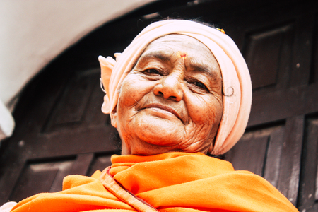 Kathmandu Nepal August 27, 2018 Closeup of unknown Sadhu with orange clothes sitting in the Pashupatinath temple in the morningのeditorial素材