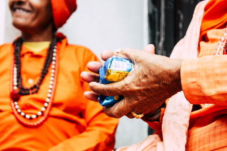 Kathmandu Nepal August 27, 2018 Closeup of unknown Sadhu with orange clothes sitting in the Pashupatinath temple in the morningのeditorial素材