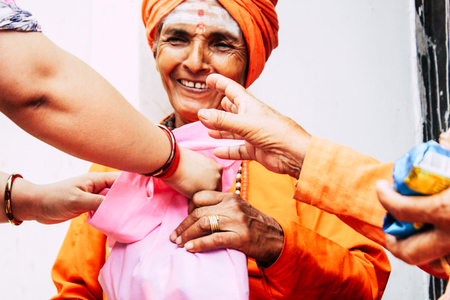 Kathmandu Nepal August 27, 2018 Closeup of unknown Sadhu with orange clothes sitting in the Pashupatinath temple in the morningのeditorial素材