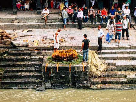 Kathmandu Nepal August 27, 2018 View of unknowns Hindu people preparing the cremation site front the river at the Pashupatinath temple in the afternoonのeditorial素材
