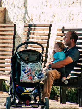 Jerusalem Israel September 11, 2018 View of a Israeli kid and father seating in a public garden in...