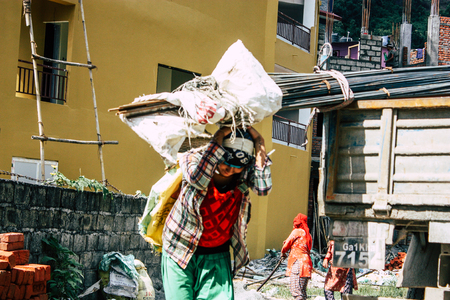 Pokhara Nepal September 23, 2018 Closeup of Nepalese porter carrying sand for construction of a new house in Pokara Lakeside in the afternoonのeditorial素材