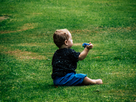 Tel Aviv Israel September 28, 2018 View of a child sitting on in a public garden in Tel Aviv in the afternoonのeditorial素材