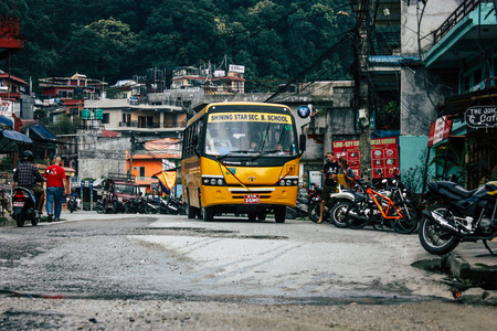 Pokhara Nepal October 4, 2018 View of a traditional Nepali yellow school bus driving in New street at pokhara in the afternoonのeditorial素材