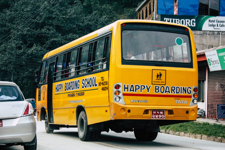 Pokhara Nepal October 4, 2018 View of a traditional Nepali yellow school bus driving in New street...