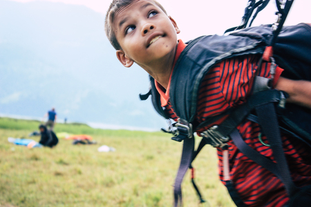 Pokhara Nepal October 6, 2018 Portrait of a young Nepali kid learning to be a paragliding pilot in the landing area front the Phewa lake of Pokharaのeditorial素材