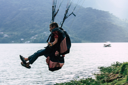 Pokhara Nepal October 6, 2018 Portrait of a young Nepali kid learning to be a paragliding pilot in the landing area front the Phewa lake of Pokharaのeditorial素材