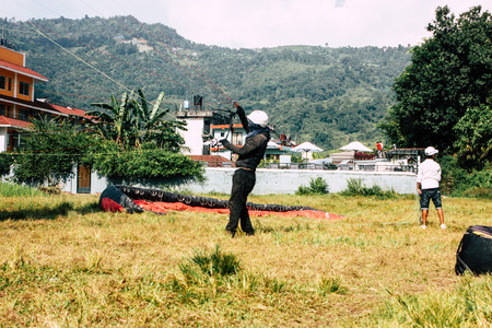 Pokhara Nepal October 6, 2018 View of a paragliding pilot landing front the Phewa lake of Pokharaのeditorial素材
