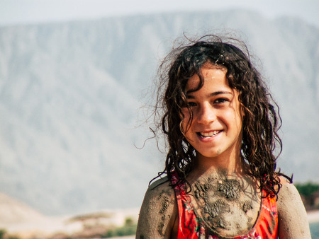 Sinai Egypt October 6, 2018 View of young happy Israeli teens with mud on the body walking on the beach in the morningのeditorial素材