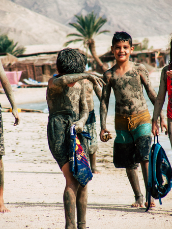 Sinai Egypt October 6, 2018 View of young happy Israeli teens with mud on the body walking on the...