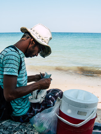 Sinai Egypt October 6, 2018 Portrait of a unknown Arabian man selling ice cream on the beach of Sinai in the morningのeditorial素材