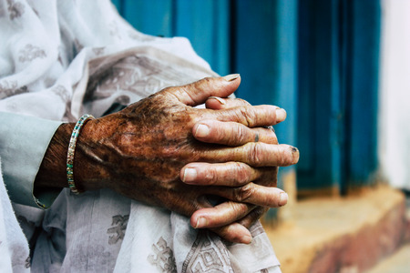 Closeup of hands of unknown old Nepalese woman sitting front her traditional house located in the main street of Bandipur in the afternoonの写真素材