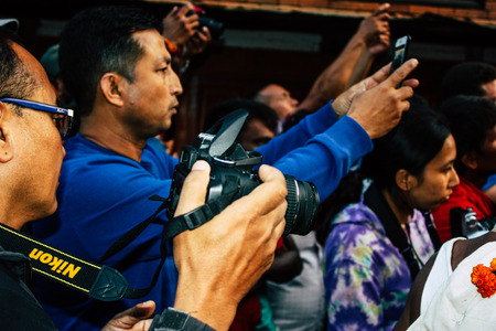 Bandipur Nepal October 18, 2018 Closeup of unknown people taking photo during a religious ceremony in Main street of Bandipur in the eveningのeditorial素材