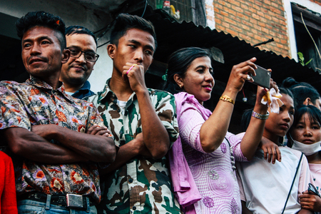 Bandipur Nepal October 18, 2018 Closeup of unknown people taking photo during a religious ceremony in Main street of Bandipur in the eveningのeditorial素材