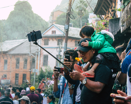 Bandipur Nepal October 18, 2018 Closeup of unknown people taking photo during a religious ceremony in Main street of Bandipur in the eveningのeditorial素材
