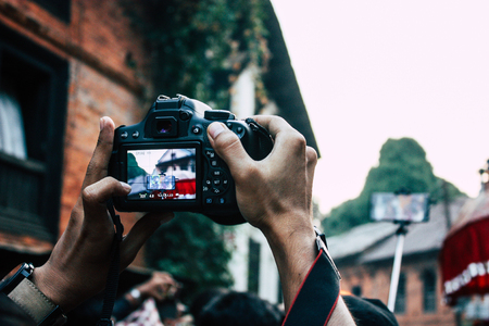 Bandipur Nepal October 18, 2018 Closeup of unknown people taking photo during a religious ceremony in Main street of Bandipur in the eveningのeditorial素材