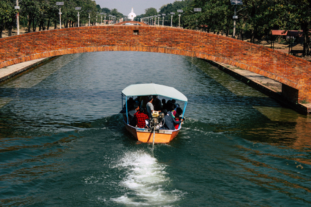 Lumbini Nepal October 31, 2018 View of a boat carrying unknowns pilgrims in the central canal of the Buddha Garden in Lumbini in the afternoonのeditorial素材