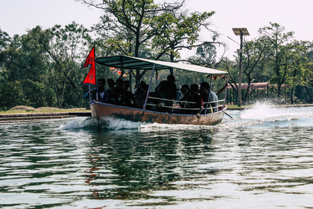 Lumbini Nepal October 31, 2018 View of a boat carrying unknowns pilgrims in the central canal of the Buddha Garden in Lumbini in the afternoonのeditorial素材