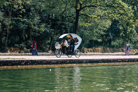 Lumbini Nepal October 31, 2018 View of a rickshaw carrying unknown pilgrims at the Buddha Garden in Lumbini in the afternoonのeditorial素材