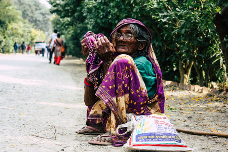 Lumbini Nepal November 3, 2018 View of unknown Nepalese old woman sitting at the entry of the Sacred...