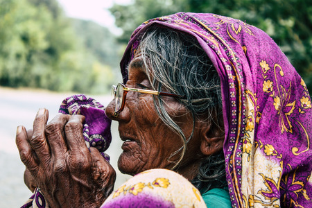 Lumbini Nepal November 3, 2018 View of unknown Nepalese old woman sitting at the entry of the Sacred  Buddha garden in Lumbini in the afternoonのeditorial素材