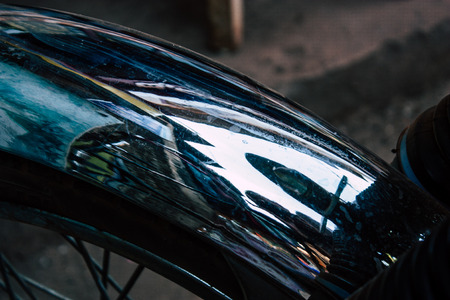 Closeup of a classic Royal Enfield motorcycle parked in the main street of Gokarna in the morningの写真素材