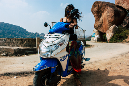 Hampi Karnataka India December 16, 2018 Portrait of Reachel Singh, Dutch professional singer driving a scooter in Hampi countryside afternoonのeditorial素材