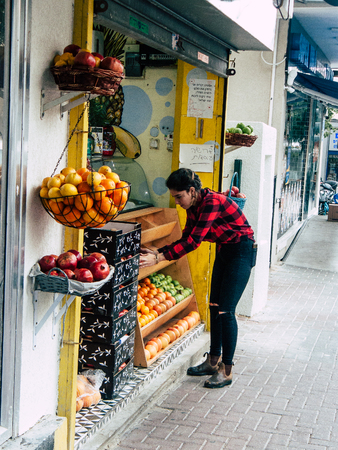 Tel Aviv Israel December 21, 2018 View of unknown Israeli girl working in a veg shp in the streets of Tel Aviv in the afternoonのeditorial素材