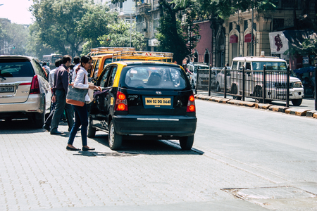 Mumbai India March 1, 2019 View of a traditional black and yellow taxi rolling in the streets of Mumbai in the afternoonのeditorial素材