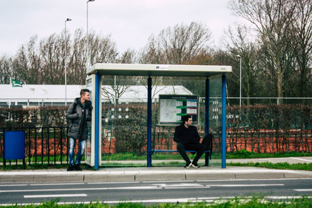 Papendrecht Netherlands March 12, 2019 View of unknown Dutch people waiting at the bus stand in the streets of Papendrecht in the afternoonのeditorial素材