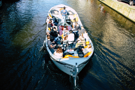Amsterdam Netherlands April 8, 2019 View of a boat in the canals at the red light district of Amsterdam in the eveningのeditorial素材