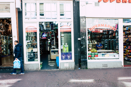 Amsterdam Netherlands April 10, 2019 View of unknown Dutch people walking in Nieuwe Hoogstraat street in Amsterdam in the eveningのeditorial素材