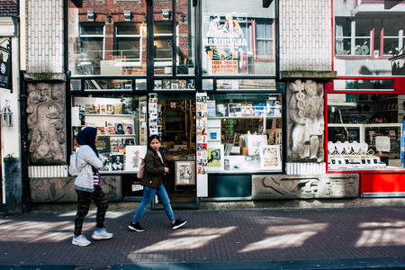Amsterdam Netherlands April 10, 2019 View of unknown Dutch people walking in Nieuwe Hoogstraat street in Amsterdam in the eveningのeditorial素材