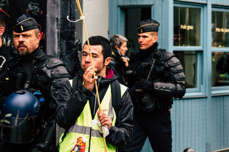 Paris France May 04, 2019 View of Yellow Jackets protesters framed by anti riot police marching...