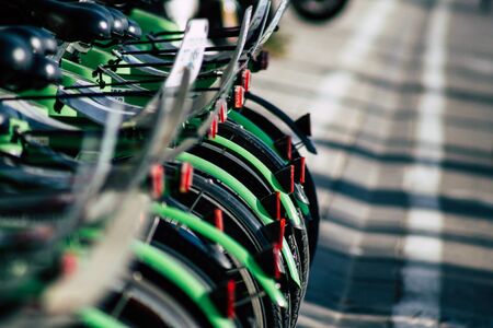 View of green electric bicycles to hire parked front the beach of Tel Aviv in the afternoonの写真素材