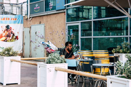 Tel Aviv Israel June 10, 2019 View of unknown Israeli people sitting on a public bench in the streets of Tel Aviv in the afternoonのeditorial素材