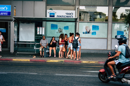Tel Aviv Israel June 07, 2019 View of unknowns Israeli people waiting at the bus stand in the streets of Tel Aviv in the afternoonのeditorial素材