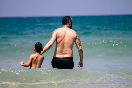 Tel Aviv Israel June 8, 2019 View of unknown Israeli children and parent having fun on the beach of Tel Aviv in the afternoonのeditorial素材